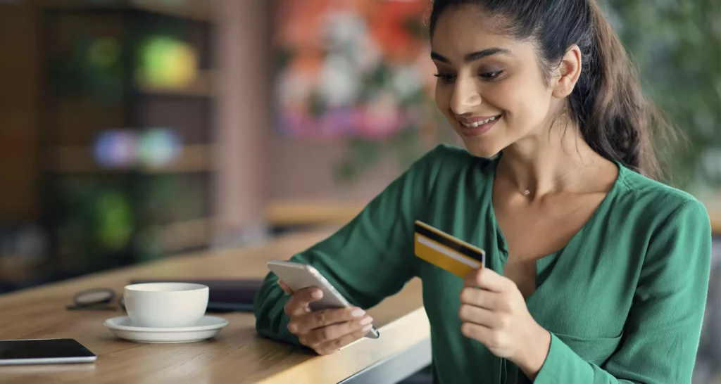 happy-young-lady-using-mobile-phone-and-credit-car